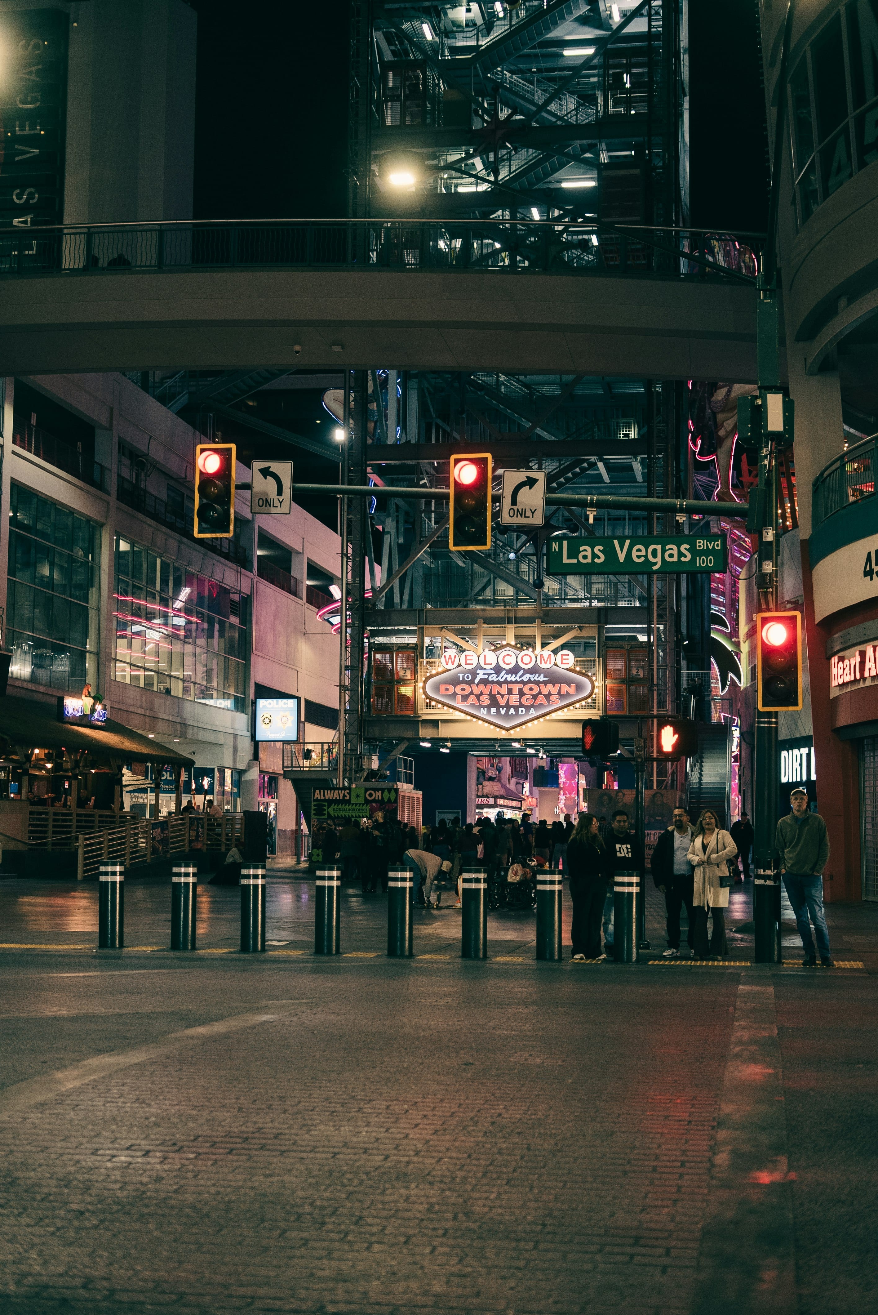 A downtown Las Vegas street at night washed in neon and sign light